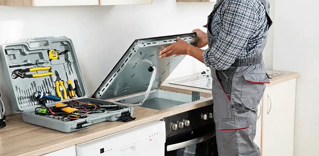 Handyman repairing a cooktop and checking wiring connections in Tampa, FL