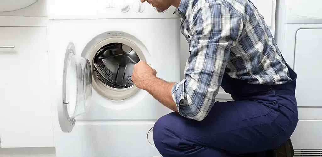 Handyman inspecting a dryer drum and internal parts for repair in Tampa, FL
