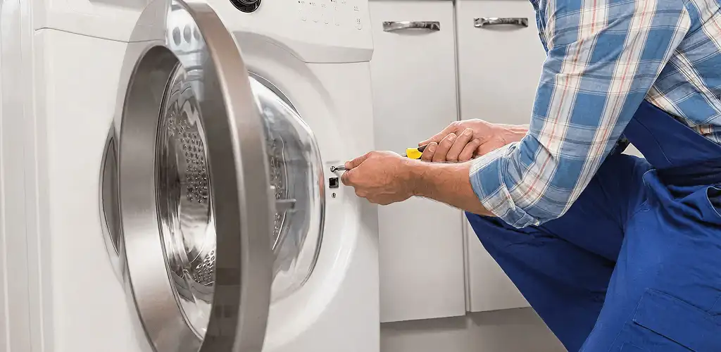Handyman repairing a clothes dryer and checking electrical connections in Tampa, FL