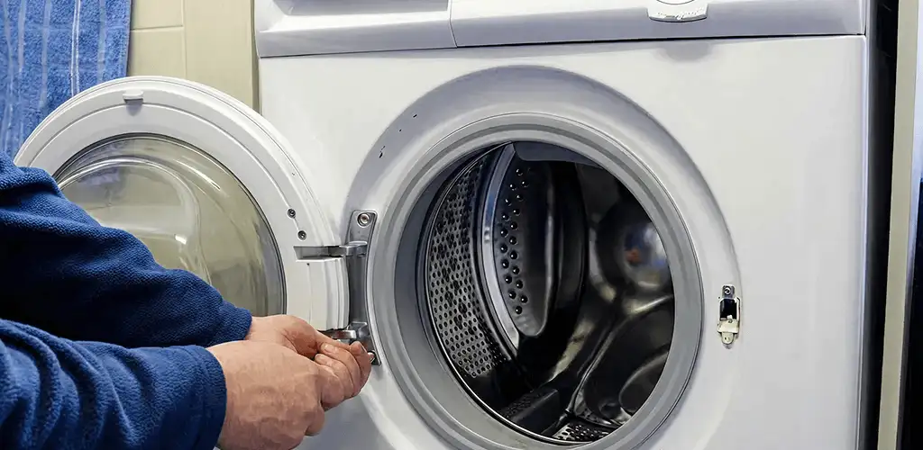 Washing machine repair handyman checking a front-load washer door and latch in Tampa, FL