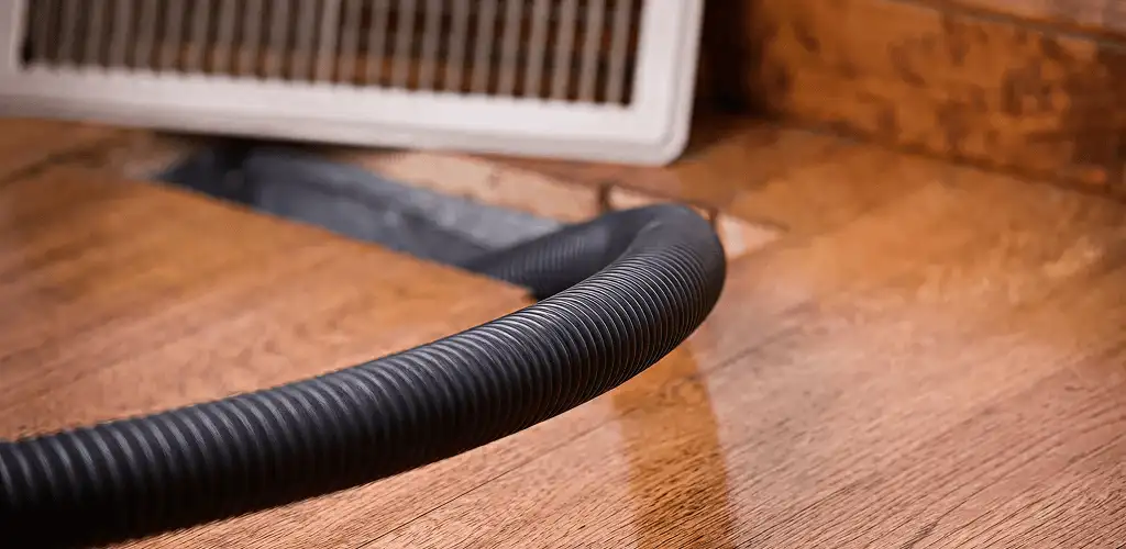 Air duct cleaning hose inserted into a floor vent for ductwork cleaning in Tampa, FL