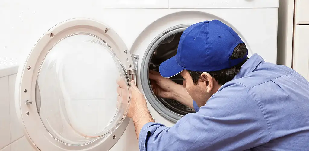 Washing machine repair handyman inspecting a front-load washer drum in Tampa, FL