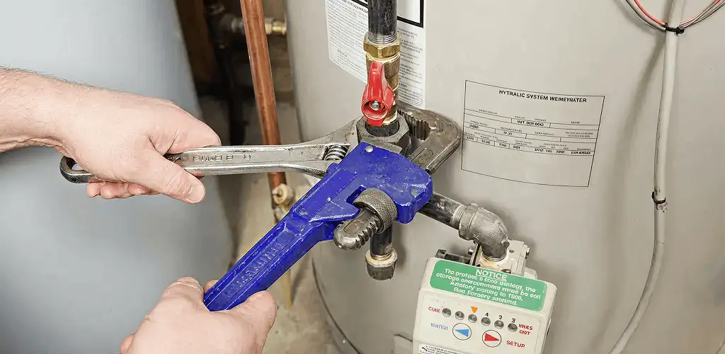 Water heater repair technician tightening the shutoff valve and supply line in Tampa, FL